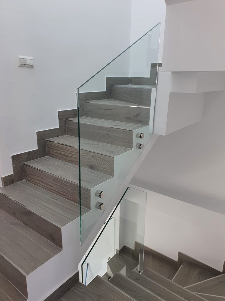 Escalera moderna con peldaños de madera y barandilla de cristal templado